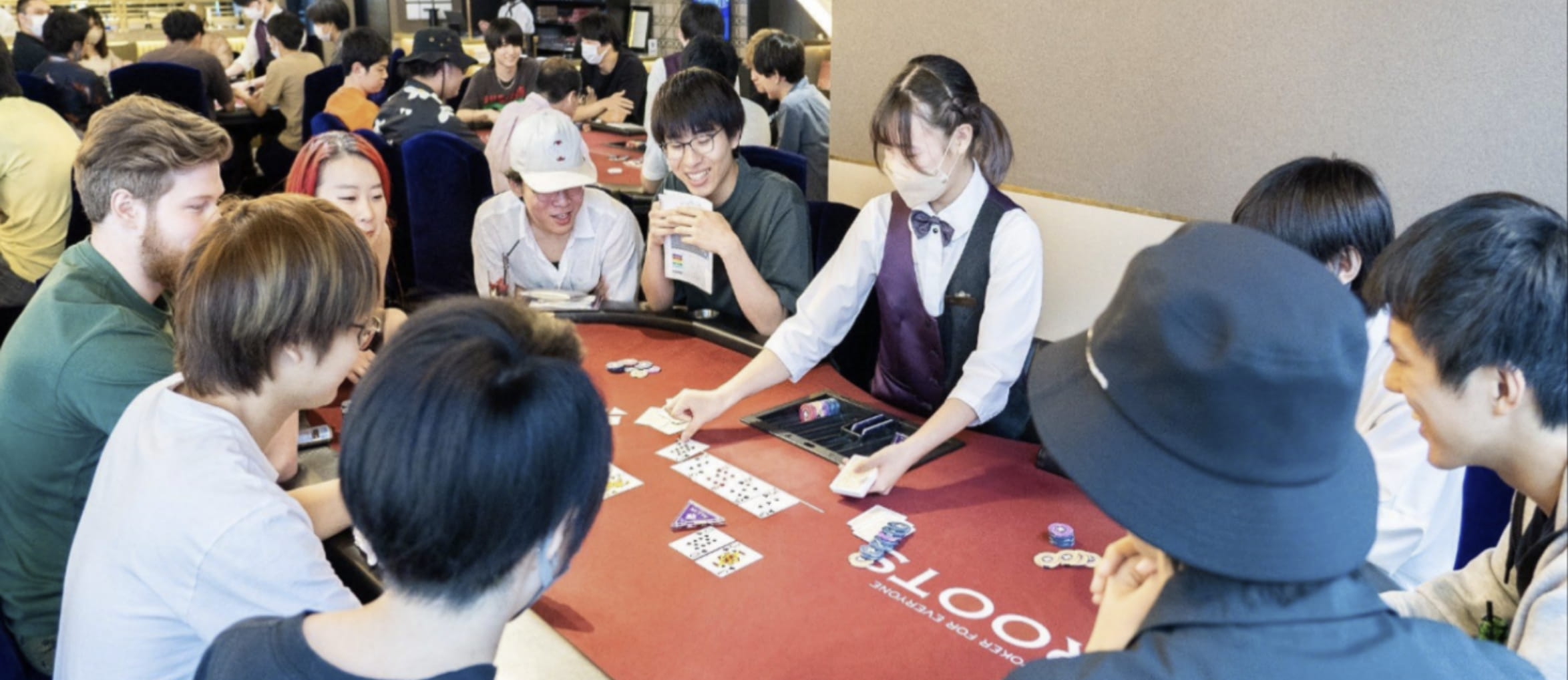 ポーカーテーブルを囲んで対戦を楽しむプレイヤーとディーラー